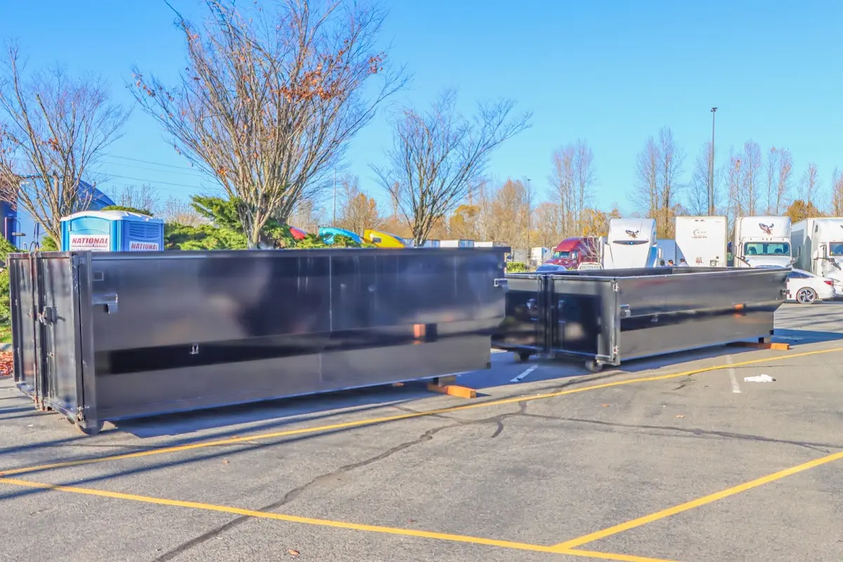 Professional dumpster rental service with roll-off container on residential driveway in Mount Morris